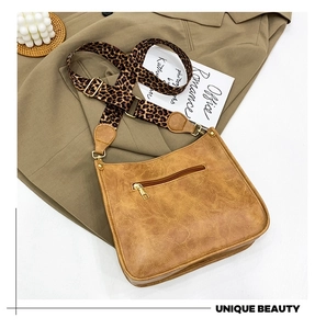 Detail of vintage brown tote bag featuring leopard print strap and back zipper pocket