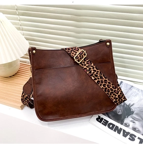 Detail of vintage brown tote bag featuring a stylish leopard print wide shoulder strap