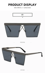 Detail of square oversized sunglasses with unique metal cross bridge design and grey lenses