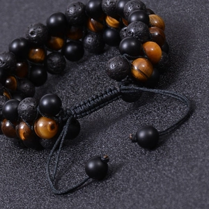 Macro shot of triple-layer tiger eye and lava stone beads with adjustable braided cord