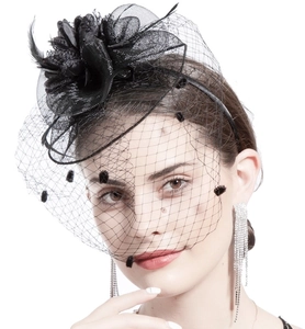 Detail of elegant black mesh fascinator veil with feather and polka dot accents
