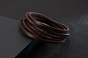 Macro detail of multi-layered brown braided leather and smooth straps on a vintage bracelet