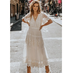 Close-up of bohemian white lace maxi dress with V-neck and tiered skirt layers