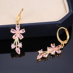 Detail of pink crystal flower drop earrings in gold-plated setting with zircon inlay