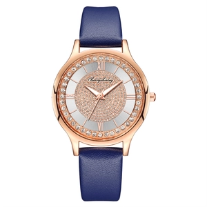 Macro view of starry rose gold watch dial with crystals and blue leather strap