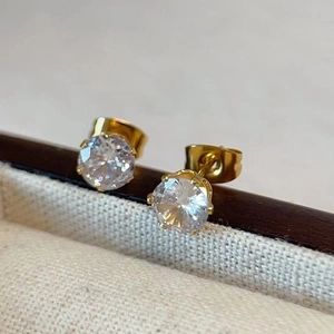 Macro detail of high-quality gold plated stud earrings with sparkling round cubic zirconia