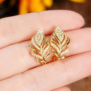 Detailed view of gold wheat ear earrings with shimmering white cubic zirconia stones