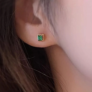 Classic gold square stud earrings with green zircon on model in a professional close-up shot