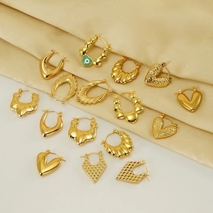 Vintage hollow geometric gold-plated earrings collection on silk background