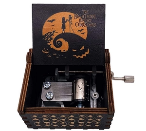 Close-up of hand-cranked wooden music box with metal gears and Nightmare Before Christmas engraving
