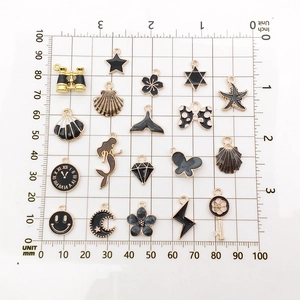 Black and gold alloy charm assortment for DIY jewelry making on measurement scale