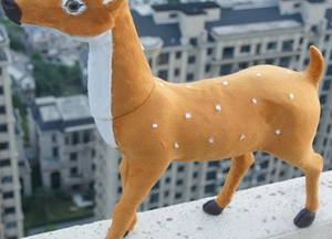 Détail d'une figurine de renne en peluche avec taches blanches sur fourrure orange