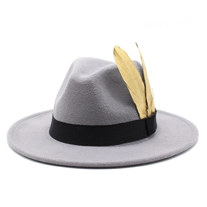 Detail of grey wool fedora hat with black ribbon and two golden feather accessories