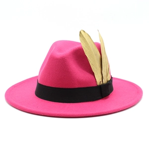 Detail of rose red fedora hat with black ribbon and golden feather metal ornaments