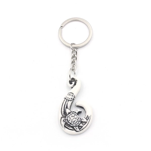 Silver alloy keychain featuring a fish hook pendant with turtle and wave engravings