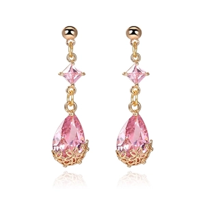 Close-up of 18K gold earrings with pink teardrop crystal and hollow floral base