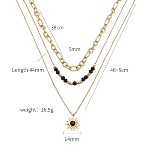 Detailed view of triple-layered gold sun pendant necklace with black beads and chain dimensions