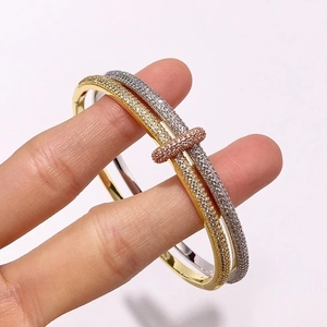 Detail of three-tone gold and silver double ring bracelet with pavé diamonds