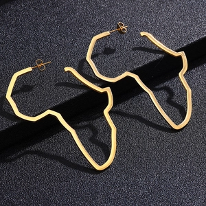 Detailed close-up of golden African map contour hoop earrings on black display stand