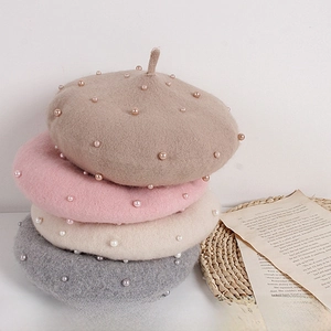 Detailed stack of kids' wool berets with pearls in camel, pink, beige and grey colors