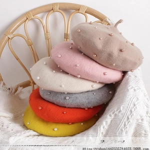 Close-up of pearl embellished kids wool berets in brown, pink, beige, and orange