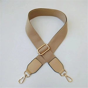 Close-up of adjustable khaki crossbody strap with gold metal buckles and leather reinforcement