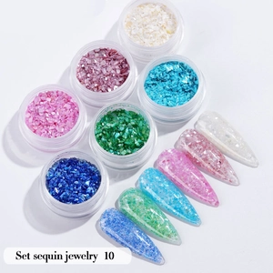 Detail view of 6 jars of colorful nail sequins and glitter with sample nail tips