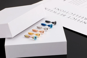 Macro shot of creative stainless steel screw earrings in six metallic colors on white props