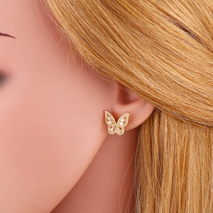 Elegant butterfly stud earrings with gold metal and shimmering white zircon stones on model