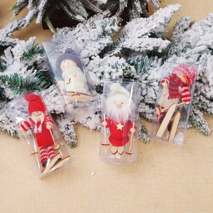 Close-up of four miniature wooden skiing dolls with knitted hats in Christmas gift boxes