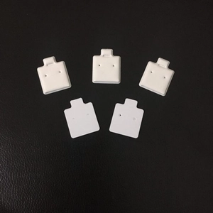 Set of five minimalist white earring display cards on black leather background