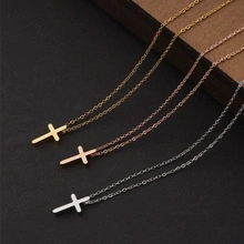 Close-up of polished stainless steel cross necklaces in gold, rose gold, and silver