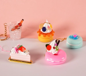 Detailed close-up of miniature resin food keychains including cake and donut charms