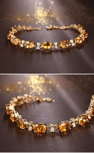 Detail view of 18k gold plated bracelet featuring oval citrine and clover motifs