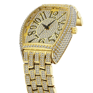 Detail of gold tonneau watch featuring full diamond setting and large black numerals