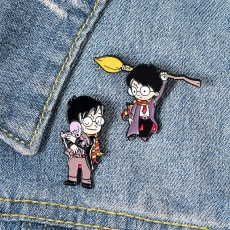 Detail of Harry Potter enamel pins with scarf and broom on blue denim fabric