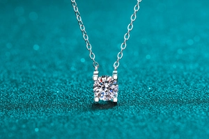 Vue rapprochée d'un pendentif en moissanite ronde avec un sertissage classique à quatre griffes