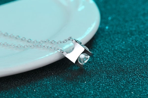 Vue macro d'un pendentif en H en argent S925 poli avec une moissanite étincelante