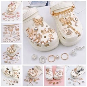 Detail of DIY shoe charms set with gold butterfly, pearl chain, and rhinestone flowers