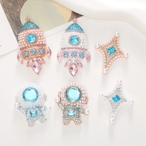 Detail of space-themed alloy pins with pearls and rhinestones for DIY crafts