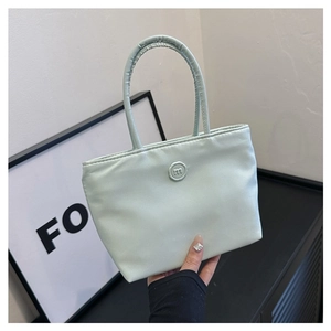 Détail du sac seau en nylon vert menthe avec anse froncée et badge logo m circulaire