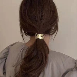 Chic gold metallic ponytail cuff with minimalist twisted design for elegant hair styling