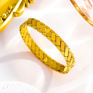 Macro detail of golden titanium steel cuff with intricate quilted cross pattern design