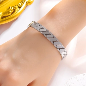 Silver woven lattice titanium steel bangle with geometric open design worn on wrist