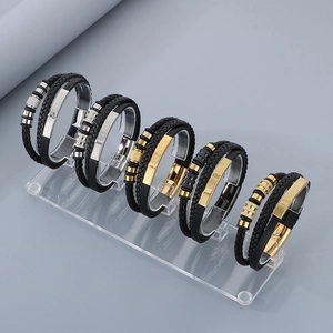 Close-up of men's multilayer braided leather bracelets with stainless steel metal charms