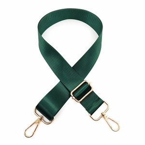 Detail of adjustable dark green nylon shoulder strap with gold metal hooks and buckles