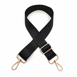 Detail of adjustable black nylon bag strap with polished gold hardware and swivel clips