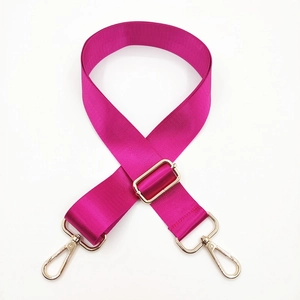 Detail of rose red nylon bag strap with adjustable gold hardware and lobster clasps