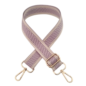 Detail of purple and beige woven bag strap with golden metal hooks and adjustable buckle