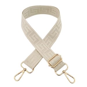 Detail of adjustable geometric Greek key pattern bag strap with gold metal buckles